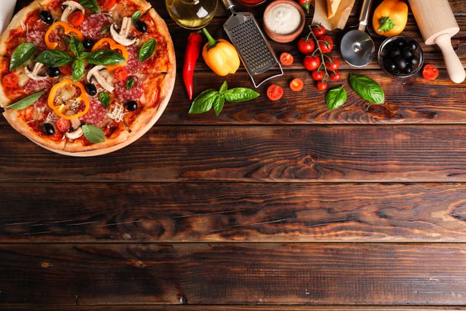 Delicious pizza and ingredients on wooden background, copy space