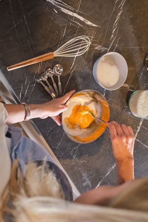 Crop woman mixing ingredients for tasty dinner