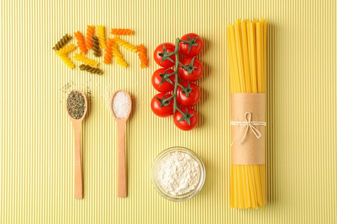 Flat lay composition with pasta ingredients on light background, space for text