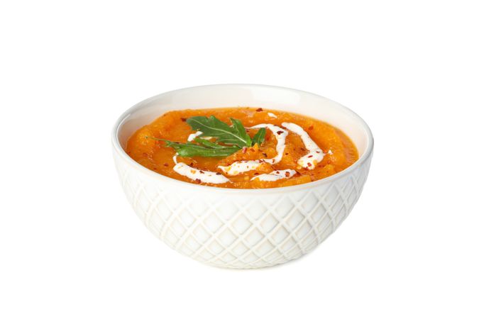Bowl of pumpkin soup with cream and herbs