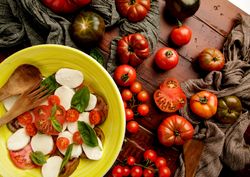 Tomatoes and napkins near bowl with salad