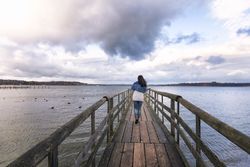 Woman walking on a bridge over calm lake in Germany