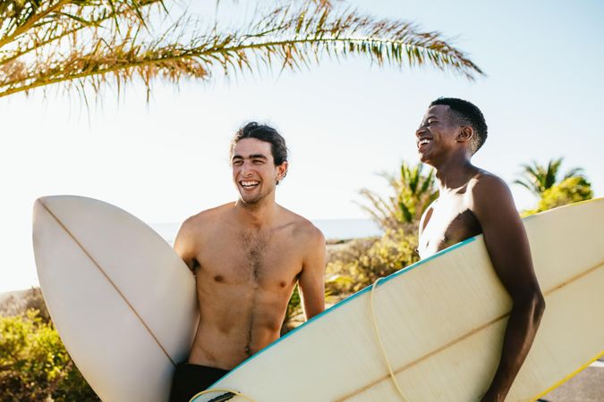 Male friends standing with surfboards