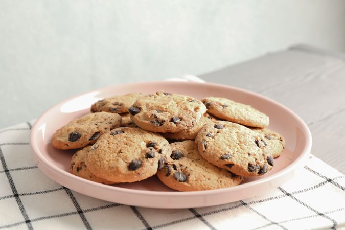 Plate with chocolate chip cookies and space for text on wooden table