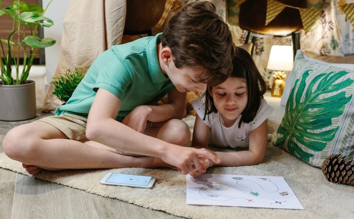 Boy and girl playing in a tent at home