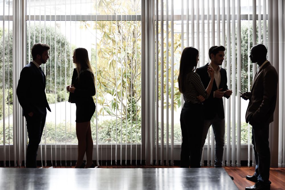 Colleagues standing near window in modern office