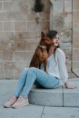 Woman with purebred dog on stone porch