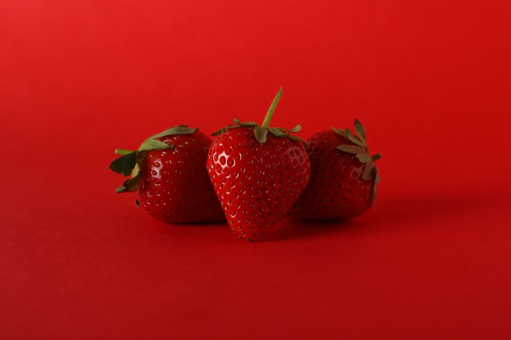 Tasty strawberry on red background. Summer berry