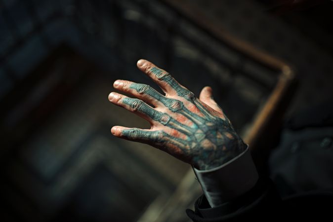Cropped image of man's hand with hand bone tattoo