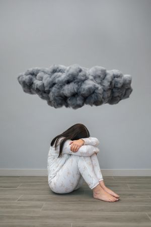 Woman crying under a dark storm cloud