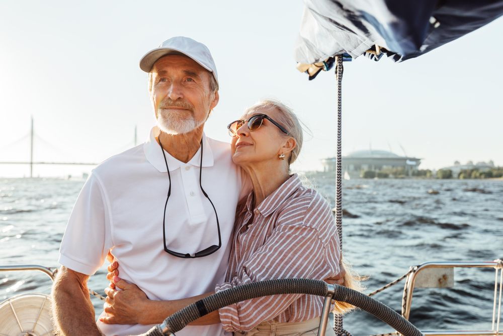 Happy older woman looking at her partner at the helm of a yacht