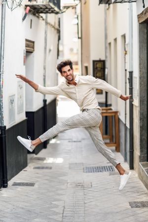 Laughing man jumping in the street
