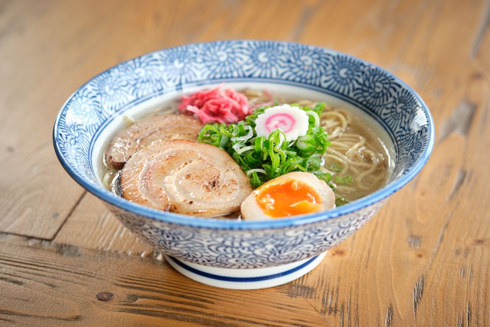 Delicious ramen soup with soft egg and pork meat in bowl