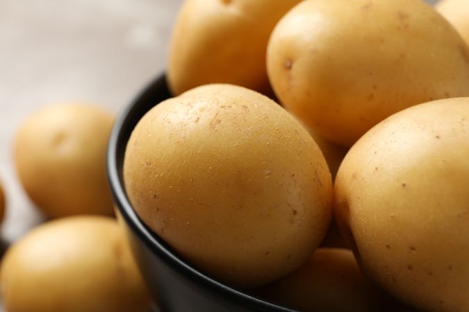 Close up of fresh potatoes in a dark ceramic bowl
