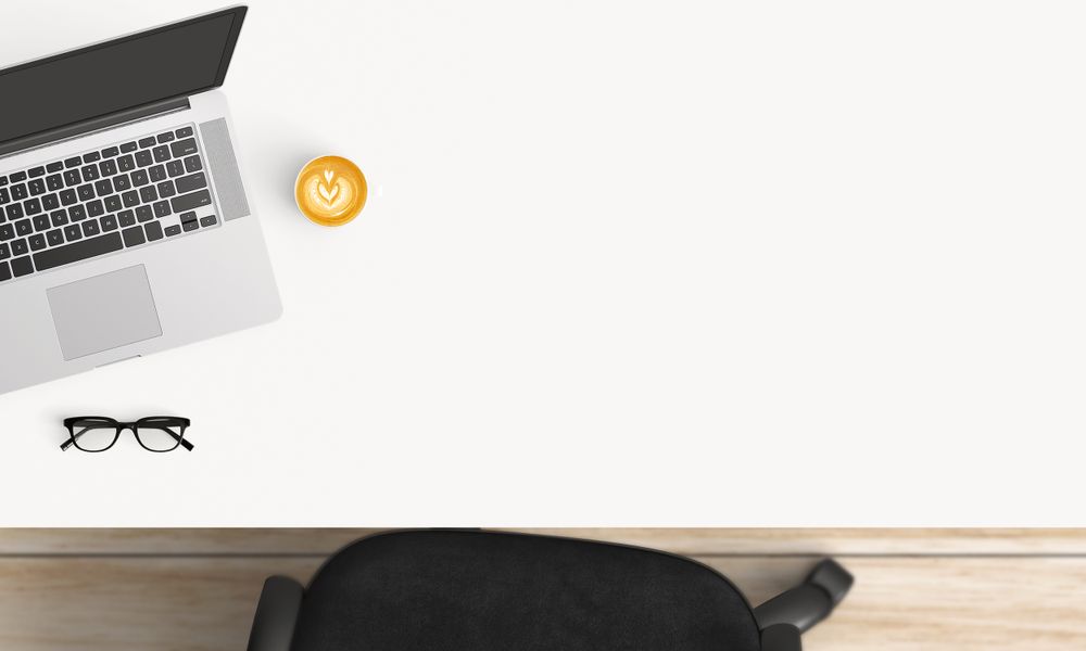 Modern workplace with laptop, coffee cup and notebook copy space on table background. Top view. Flat lay style.