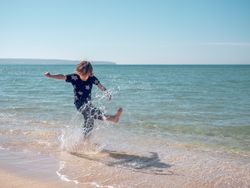 Boy playing with water on beach