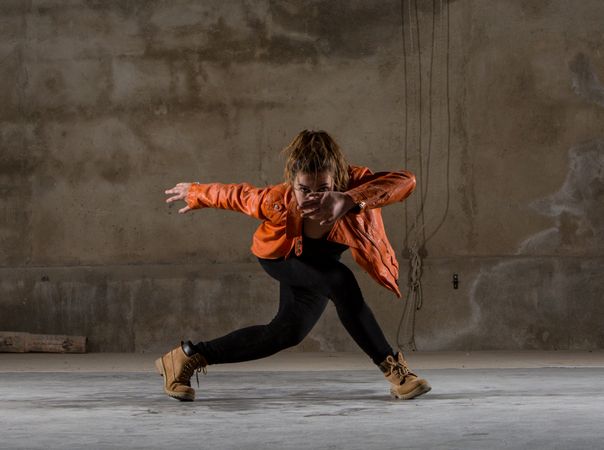 Young woman jumping in grey room