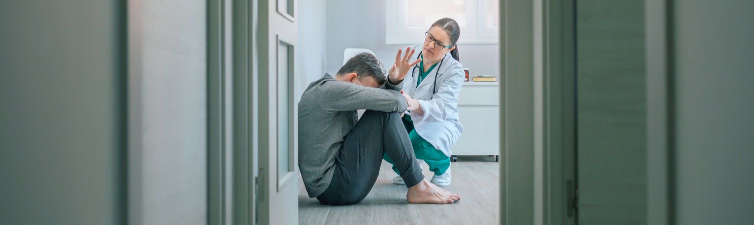 Female doctor trying to help male patient