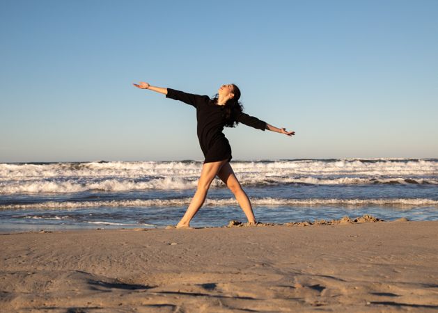 Woman with dancing near water on shore