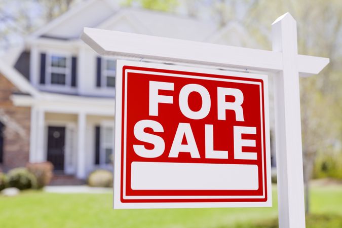 For Sale Real Estate Sign in Front of Beautiful House.