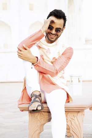 Man wearing kurta smiling and sitting outdoor