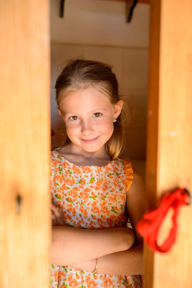 Smiling girl with crossed arms in floral sundress