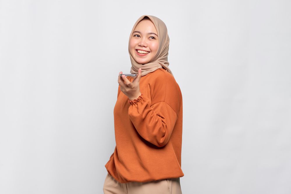 Portrait of Muslim woman talking on smart phone speaker
