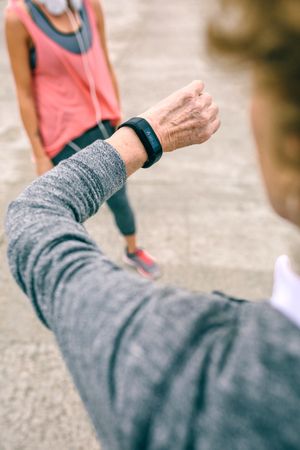 Older woman looking smart watch with female coachr