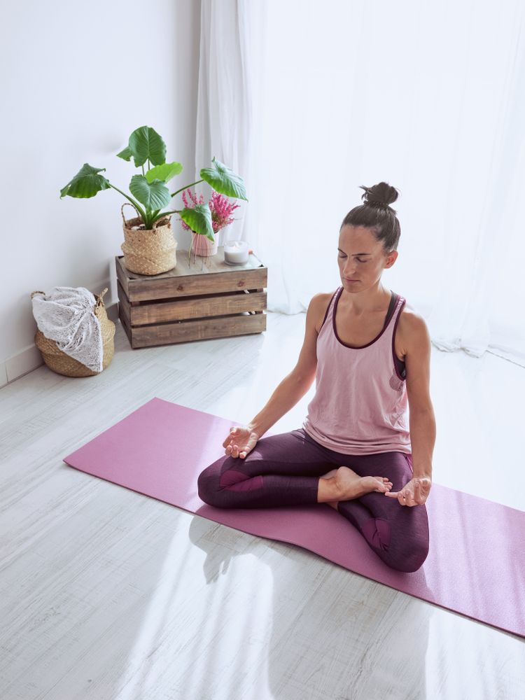 Female meditating in lotus pose with hands stretched in gyan mud