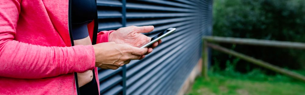Unrecognizable female athlete with mobile phone