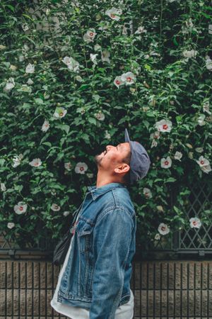 Man standing beside flowers while looking up