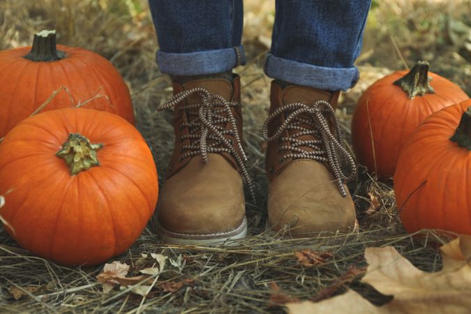 Autumn concept with pumpkins and woman in jeans and boots