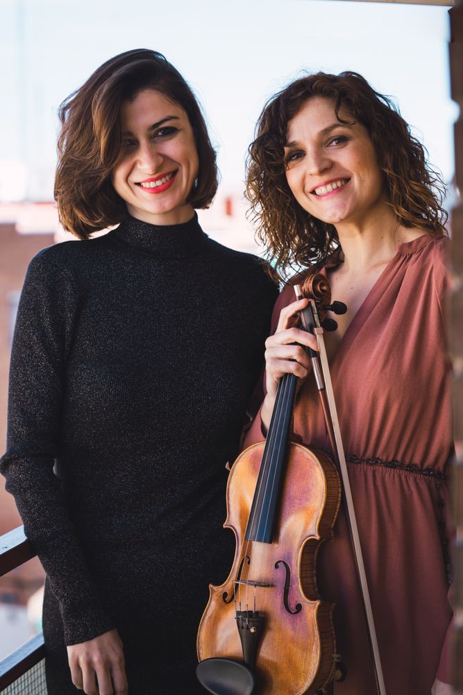 Young smiling women with violin on balcony