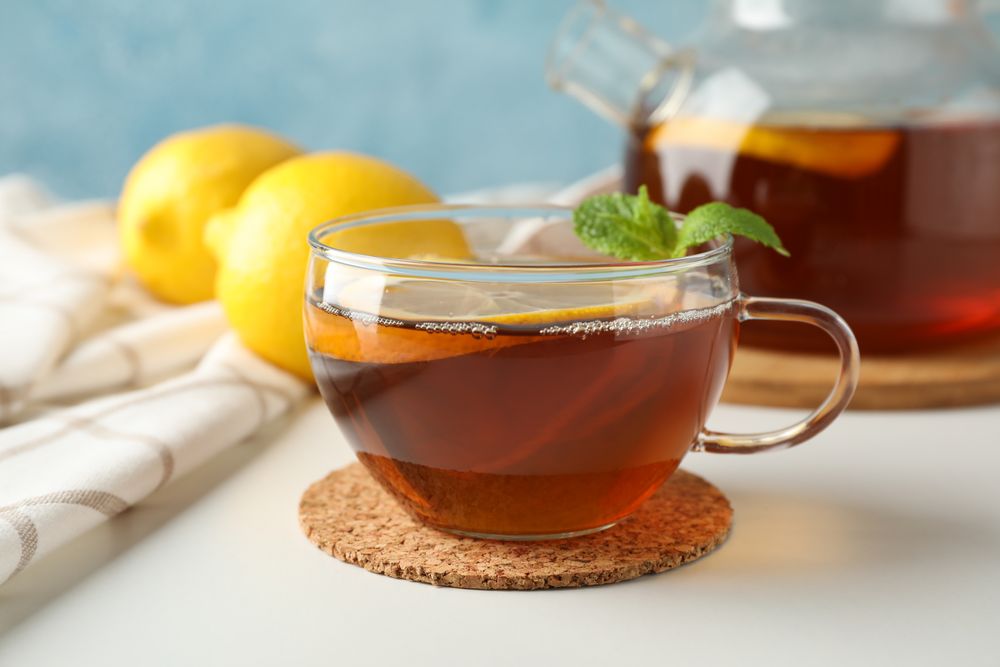 Cup of tea, mint, lemon, tea pot and towel, copy space