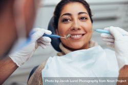 Smiling woman getting her teeth checked by dentist 5aAwQ5