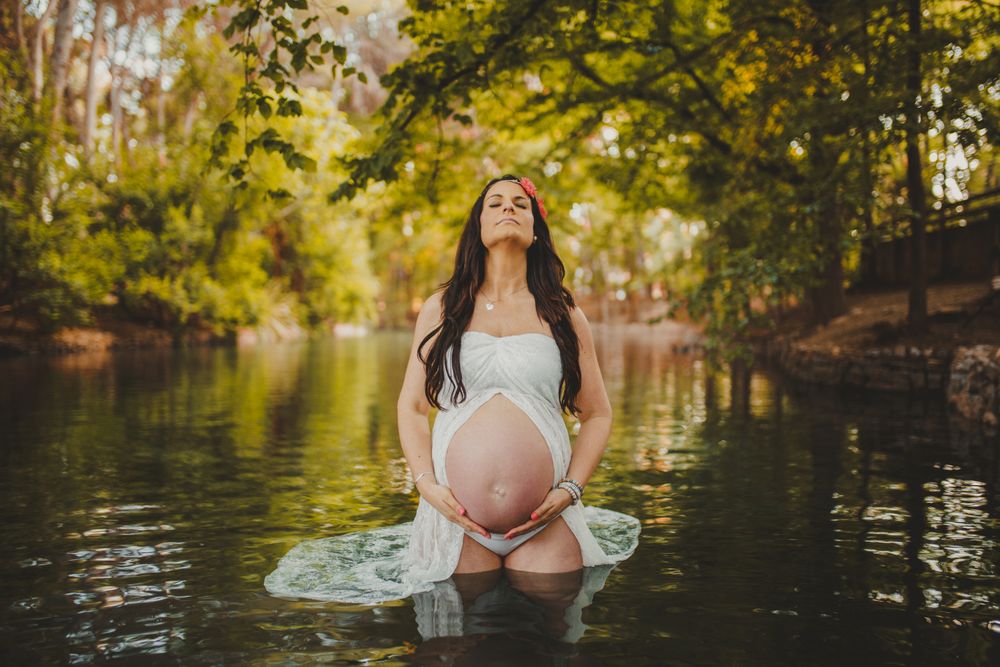 Pregnant woman standing in lake water