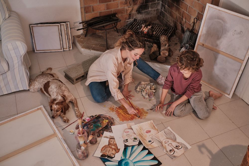 Female artist teaching boy how to paint abstract picture