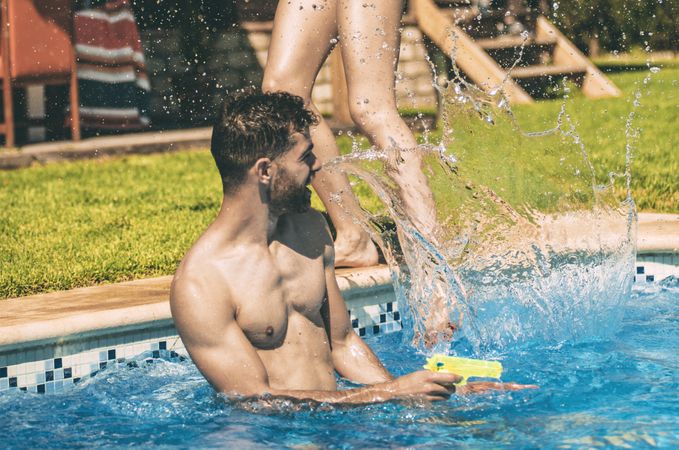 Man and woman splashing in pool