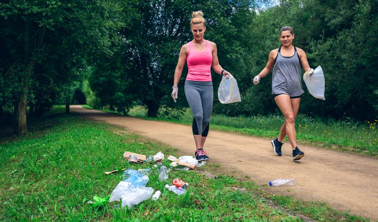 Waste pile and two woman doing plogging