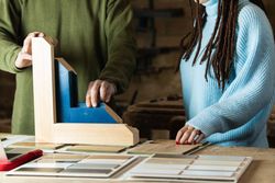 Carpenter making wooden frame while talking to client