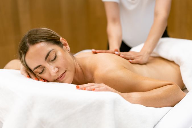 Massage therapist working on a female client’s lower back