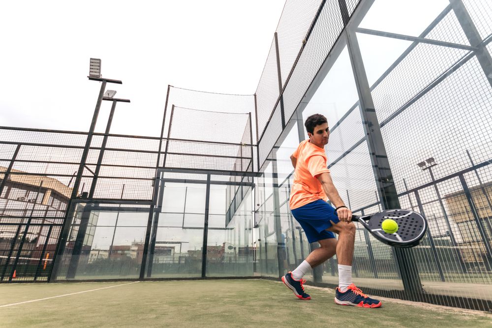 Young man playing paddle tennis. low angle