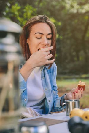 Woman eating cake for breakfast into the forest