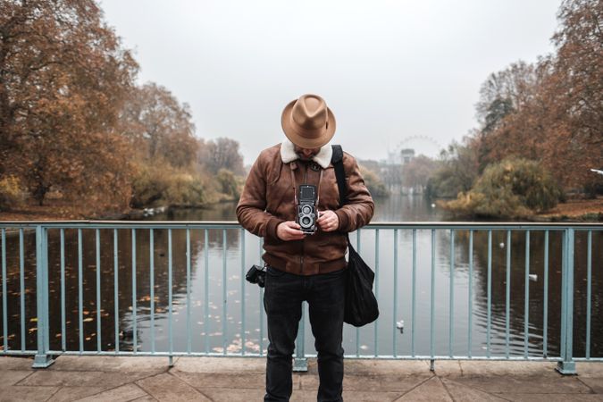 Male tourist with vintage camera near river