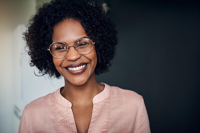 Portrait of smiling woman wearing glasses and pink shirt