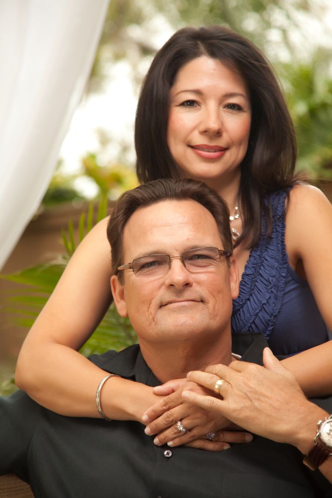 Portrait of Couple In Front Of Fern With Woman Holding Man