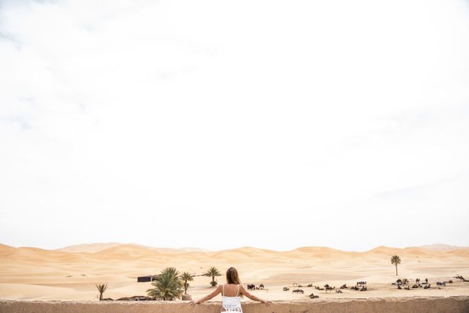 Anonymous woman on terrace against desert landscape