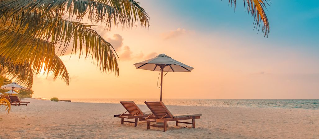 Lounge chairs on the beach at sunset