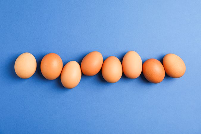 Flat lay composition with chicken eggs on color background, space for text