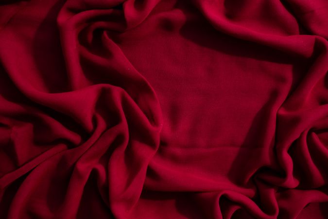 Red fabric wavy crumpled background texture with copy space.